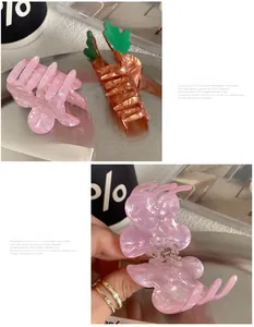 Détail de la pince à cheveux en forme de fleur rose et de la pince en forme de carotte