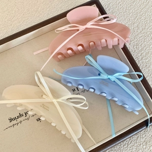 Blue, pink and white acetate hair claws with ribbon bows in a decorative tray