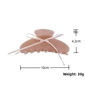 Detailed view of pink acetate hair claw clip with white ribbon showing 10cm size dimensions