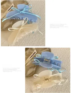 Detail view of acetate hair claw clips with blue and cream ribbon bows for women