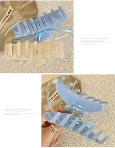 Detail view of large matte hair claw clips with blue ribbon decor and double-row teeth