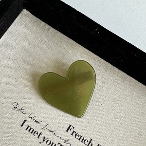 Detail of a heart-shaped leopard pattern hair clip with gold France lettering on surface
