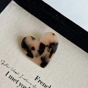 Close-up of tortoise shell heart hair clip with France Handmade lettering text