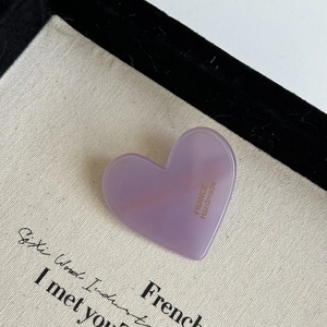 Detailed close-up of purple heart hair clip with France Handmade text on marble texture