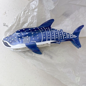 Détail d'une pince à cheveux requin-baleine en acétate bleu avec une finition brillante