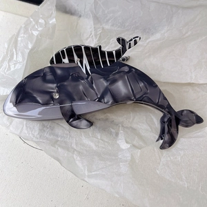 Détail de la pince à cheveux baleine en acétate avec texture marbrée et accents de strass