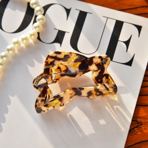 Detail of tortoise shell hair claw with rhinestones on a stylish Vogue magazine backdrop
