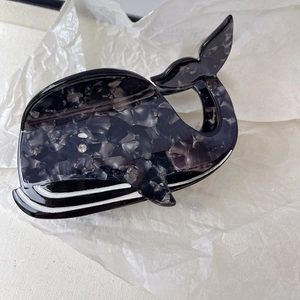 Vue detaillee d'une pince a cheveux en forme de baleine avec texture marbre et strass