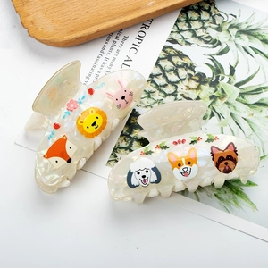 Detail of large hair claws with animal prints on pearlescent acetate finish