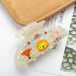 Detail of a large pearlescent hair claw with cute animal prints and floral patterns