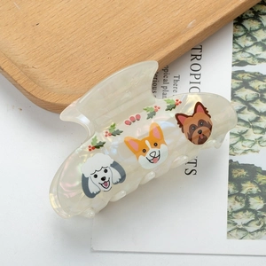 Macro detail of creamy pearl hair claw clip with cute cartoon dog and berry prints