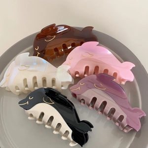 Cellulose acetate dolphin hair claws in various marbled colors and sleek dolphin shapes