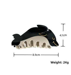Detail view of dolphin-shaped hair claw with 8.9cm length and 4.1cm height specs