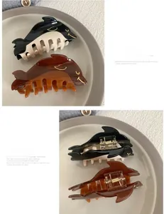 Close-up detail of acetate dolphin hair claws in beige, black and brown tortoise shell