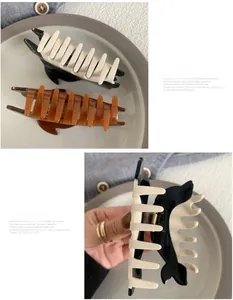 Detail of acetate shark hair claw clips in black, white, and amber with strong grip