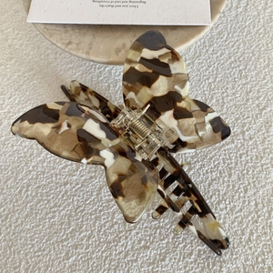 Detail of the butterfly acetate hair claw with brown marble texture and metal spring