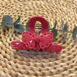 Détail de la pince à cheveux rose avec un motif de nœud en dentelle évidée raffiné