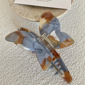 Blue-grey and amber marble pattern butterfly hair claw clip made of acetate resin