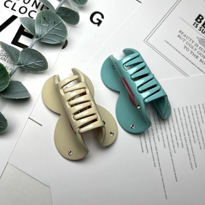 Detail of cream and teal rhinestone-studded heart hair claws for styling hair