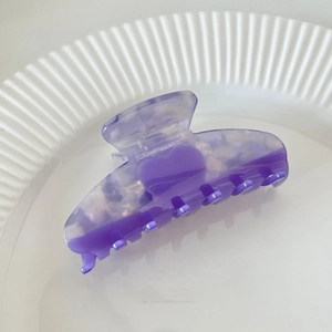 Detail of heart-shaped marbled acetate hair claw clip with purple patchwork design