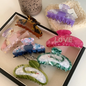 Elegant heart-shaped acetate hair claws and rhinestone shark clips in various patterns