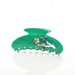 Détail de la pince à cheveux en acétate vert avec paillettes et fleurs en strass élégantes