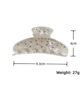 Détail de la pince à cheveux avec strass et motif marbre crème, longueur de 9,3 cm