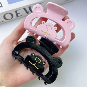 Pinces à cheveux ours évidées en rose et noir avec détails souriants en strass