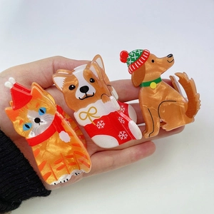 Detailed view of three acrylic Christmas hair claws with cat and dog festive designs