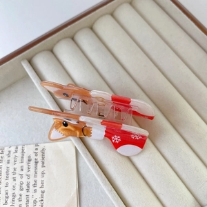 Detail of Corgi hair claw with festive red scarf and snowflake patterns for Christmas