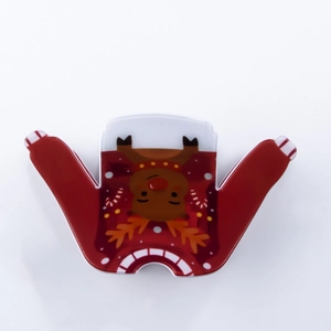 Détail d'une pince à cheveux en forme de pull rouge avec motif de renne de Noël