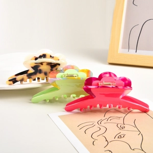 Three acetate flower hair clips in leopard, marble green, and pink colors displayed together
