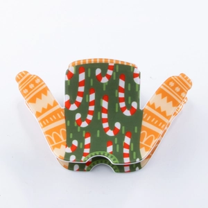 Détail d'une pince à cheveux en forme de pull de Noël avec des motifs de canne en sucre