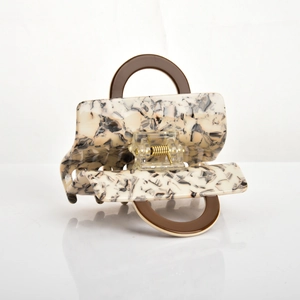 Detail of acetate hair claw clip with marble pattern and double brown ring handles