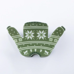 Détail d'une boîte en forme de pull de Noël vert avec des motifs de rennes et de flocons