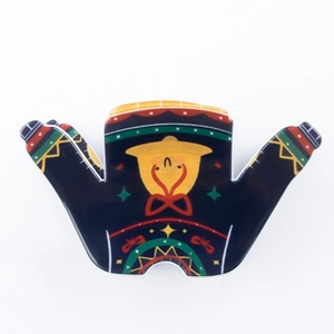 Pince à cheveux de Noël en forme de pull avec des motifs festifs colorés sur fond blanc