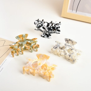 Detailed view of four acetate hair claws with premium marble and tortoiseshell patterns