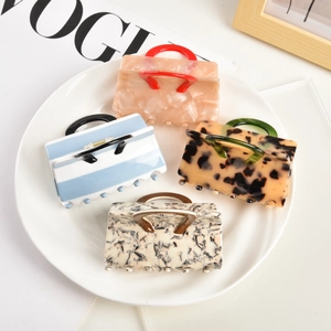 Set of four luxury acetate hair claws in handbag shape with marble and tortoiseshell patterns