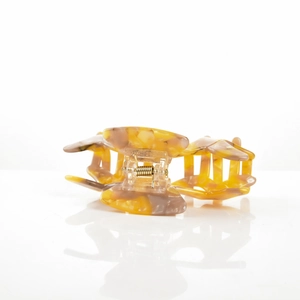 Detailed view of hollow acetate hair claw clip featuring amber texture and metal spring