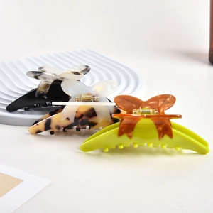 Macro view of large butterfly acetate hair claws showing marble textures and metal springs