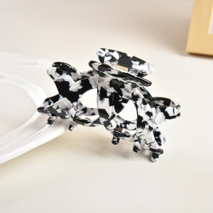Detailed view of hollow acetate hair claw clip with black and white marble texture