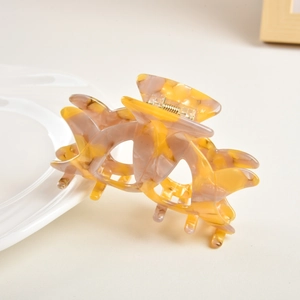 Macro detail of amber and grey marble texture acetate hair claw with gold spring