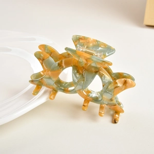 Detail of green and amber tortoise shell hair claw clip with strong golden spring