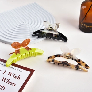 Three acetate butterfly hair claws in assorted colors with durable metal springs for women