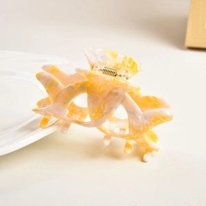 Detail of hollow marble texture hair claw clip with cream and yellow acetate finish