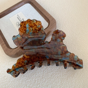 Dettaglio macro di una grande pinza per capelli in acetato tartarugato e blu ghiaccio