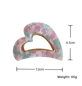 Detail view of heart-shaped acetate claw clip with floral marble pattern and dimensions