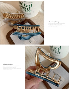 Detailed close-up of marble pattern acetate hair claws in beige and navy blue colors