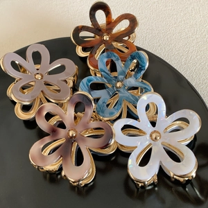 Elegant floral acetate hair claws set in tortoiseshell and marble colors with gold metal clips