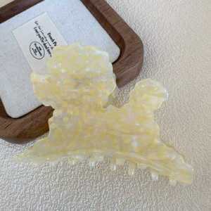 Dettaglio della simpatica pinza per capelli a forma di barboncino giallo a macchie